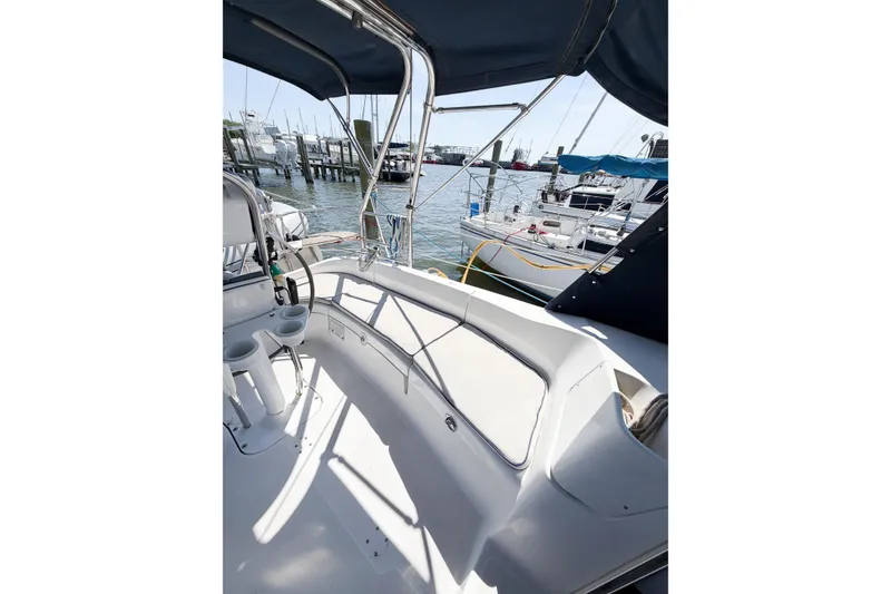 Slide: The Image of 2005 Hunter 36 sailboat cockpit with seating, cup holders, and marina view. - 17