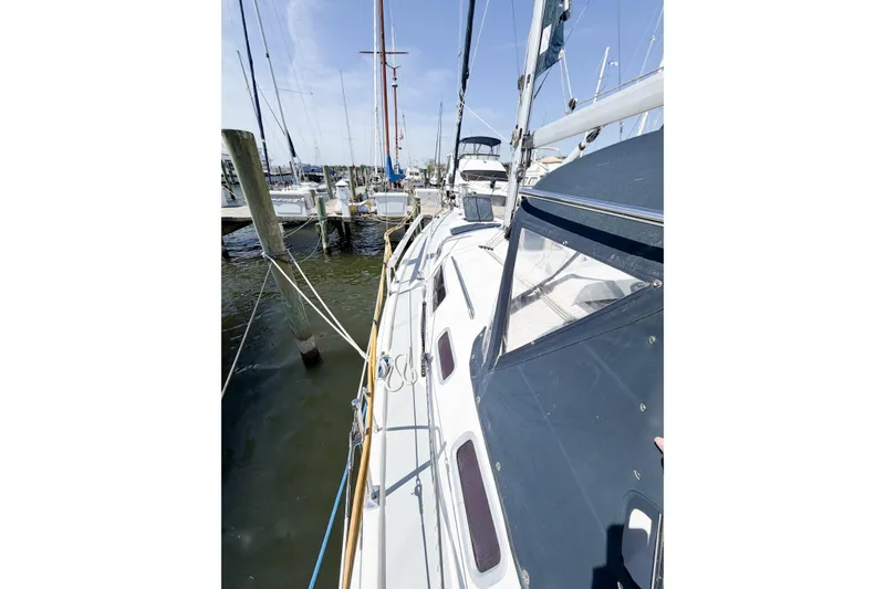 Slide: The Image of 2005 Hunter 36 sailboat docked at marina, showcasing deck and rigging. - 18