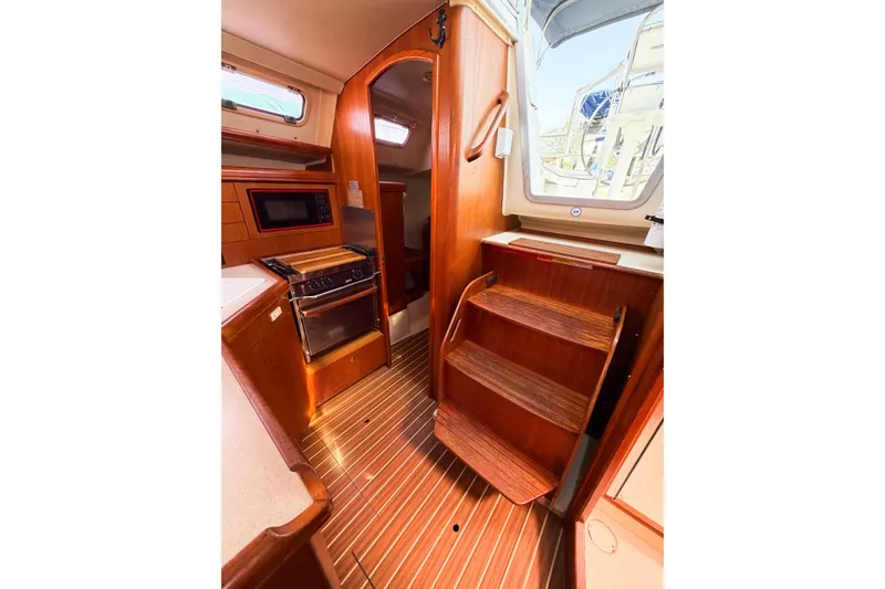 Slide: The Image of Interior of 2005 Hunter 36 sailboat with wooden stairs and compact kitchen area. - 33