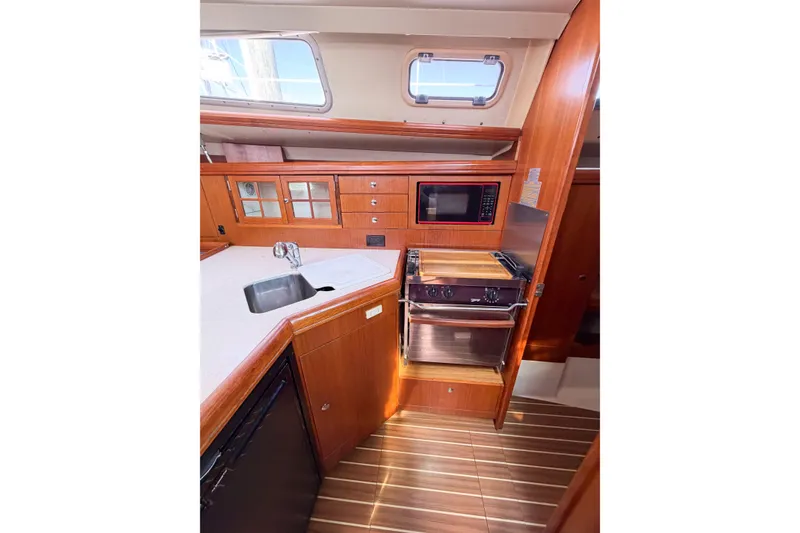 Slide: The Image of Interior of 2005 Hunter 36 sailboat galley with wood cabinetry and modern appliances. - 34