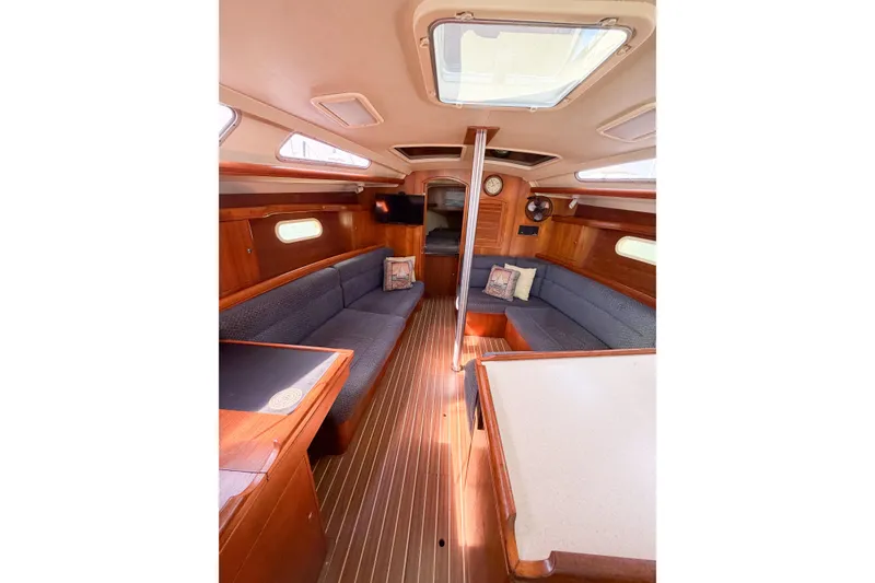 Slide: The Image of Interior of a 2005 Hunter 36 sailboat with wood finish and blue seating. - 36