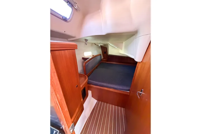 Slide: The Image of Interior cabin of a 2005 Hunter 36 sailboat with wooden finishes and cozy sleeping area. - 38