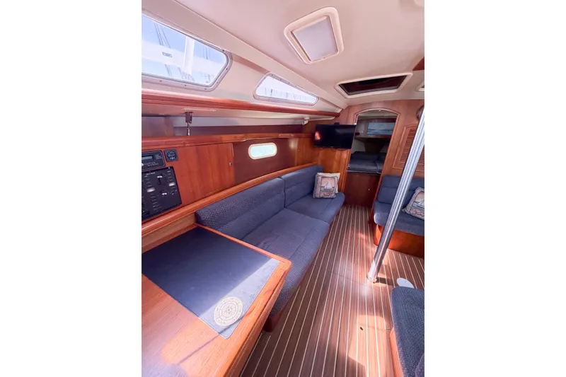 Slide: The Image of Interior of 2005 Hunter 36 sailboat with wood finish and blue seating. - 44