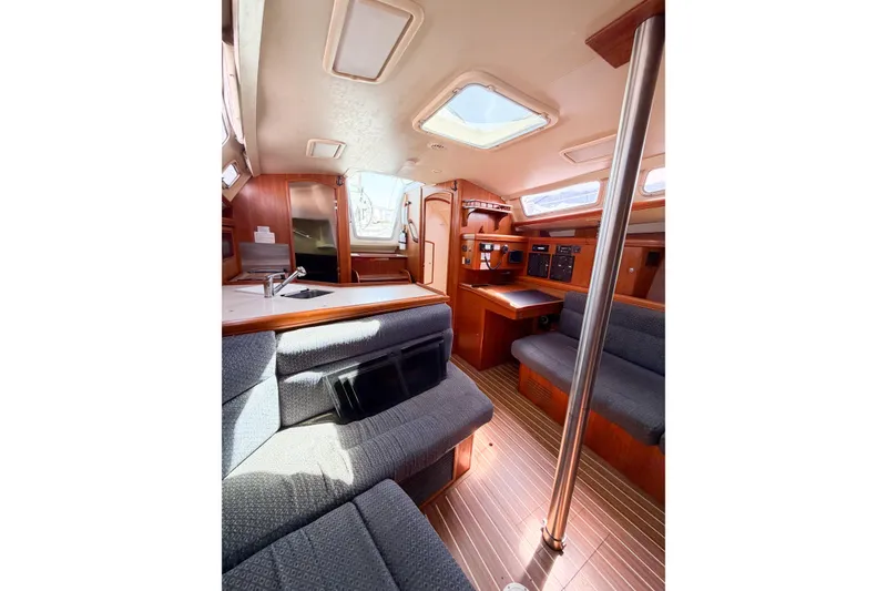 Slide: The Image of Interior of a 2005 Hunter 36 sailboat with wood finish and seating area. - 48