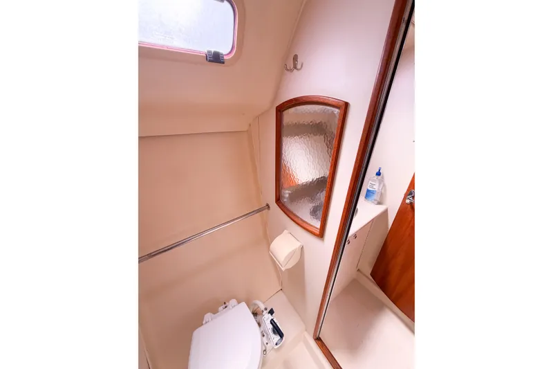 Slide: The Image of Compact bathroom in a 2005 Hunter 36 sailboat, featuring a toilet and mirror. - 54
