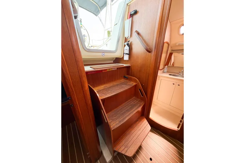 Slide: The Image of Interior view of 2005 Hunter 36 sailboat with wooden steps and compact kitchenette. - 56