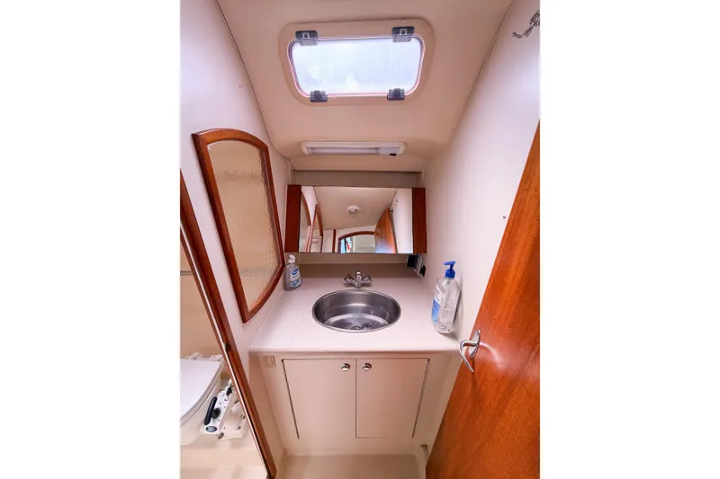 Slide: The Image of 2005 Hunter 36 yacht bathroom with sink, mirror, and storage cabinet. - 63