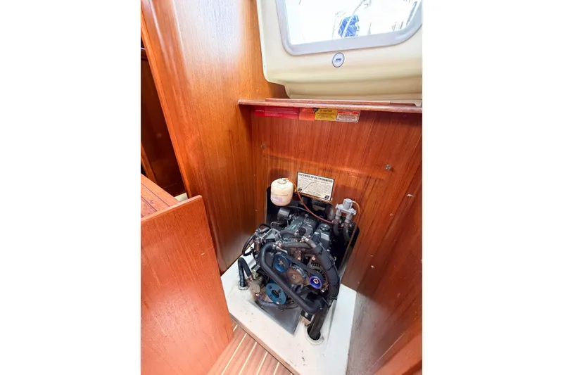 Slide: The Image of Engine compartment of a 2005 Hunter 36 sailboat, showcasing the engine and wooden interior. - 71