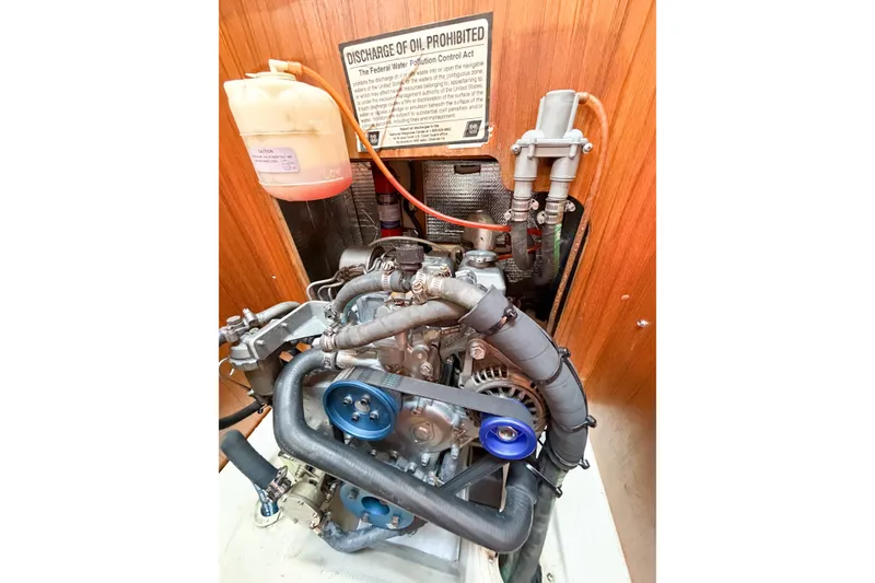 Slide: The Image of Engine compartment of a 2005 Hunter 36 sailboat with visible components and warning sign. - 72