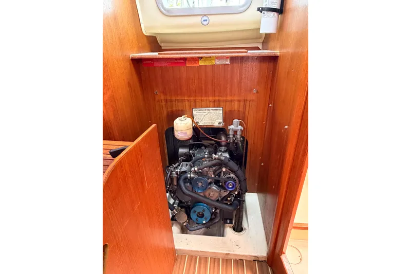 Slide: The Image of Engine compartment of a 2005 Hunter 36 sailboat, showcasing the engine and wooden interior. - 75