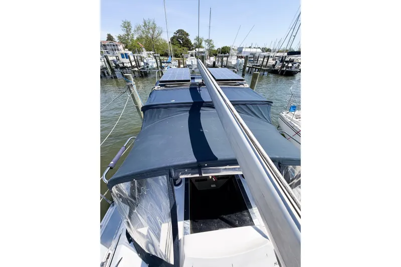 Slide: The Image of 2005 Hunter 36 sailboat with solar panels docked at a marina. - 76