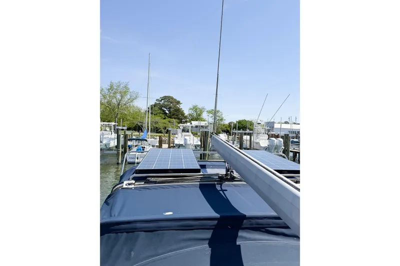 Slide: The Image of Hunter 36 sailboat (2005) with solar panels docked at marina under clear blue sky. - 77