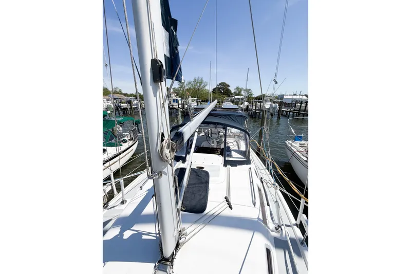 Slide: The Image of 2005 Hunter 36 sailboat docked at marina, featuring mast and cockpit view. - 79
