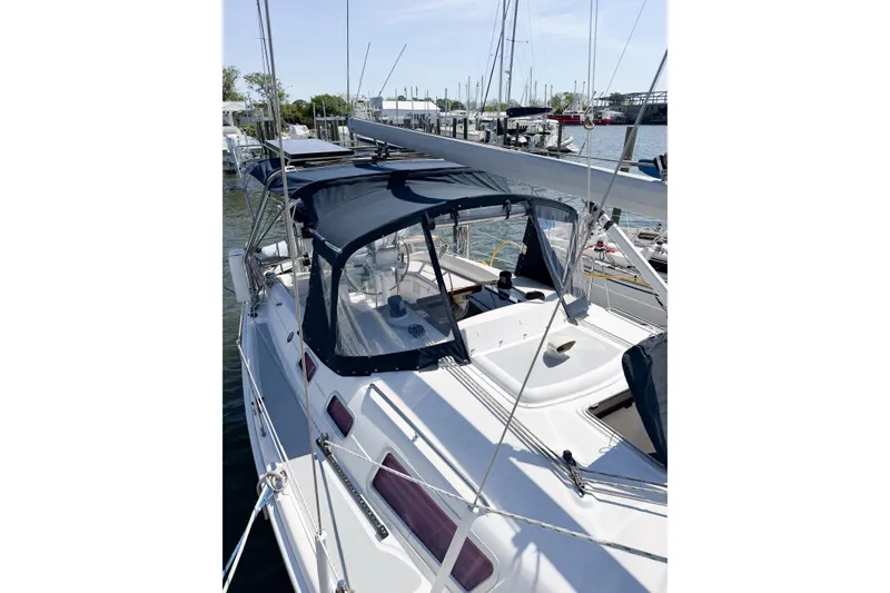 Slide: The Image of 2005 Hunter 36 sailboat docked at marina with blue canopy and clear skies. - 8
