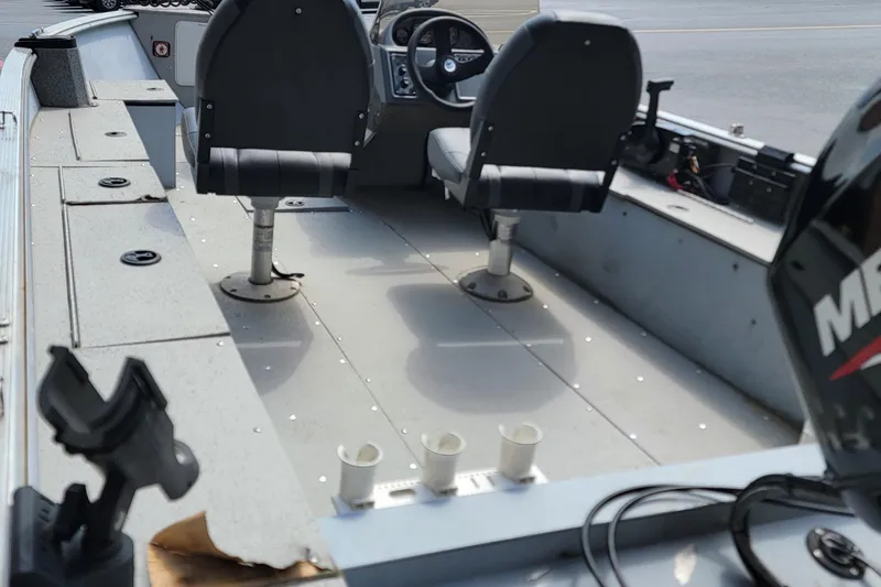 Slide: The Image of 2006 Lund 2000 Alaskan SS boat interior with seating and motor, showcasing fishing setup. - 6