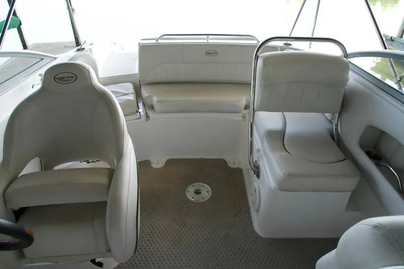 Slide: The Image of 2008 Ebbtide 2460 Z-Trak SS DC FC boat interior with white seating and steering area. - 14