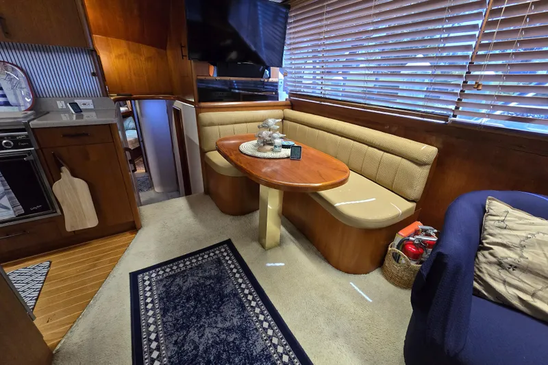 Slide: The Image of Interior of 1993 Ocean Yachts 53 Super Sport with cozy dining area and wooden accents. - 11