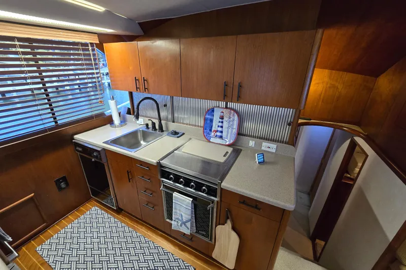 Slide: The Image of 1993 Ocean Yachts 53 Super Sport kitchen with wooden cabinets and modern appliances. - 12