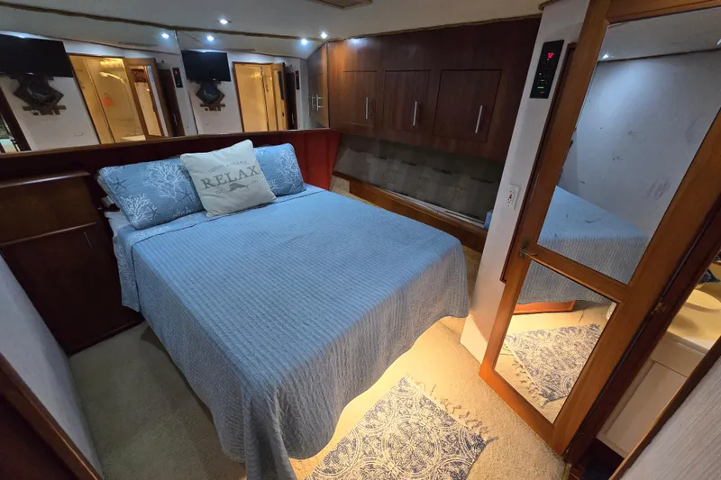 Slide: The Image of Bedroom interior of 1993 Ocean Yachts 53 Super Sport with cozy bedding and wooden cabinetry. - 16