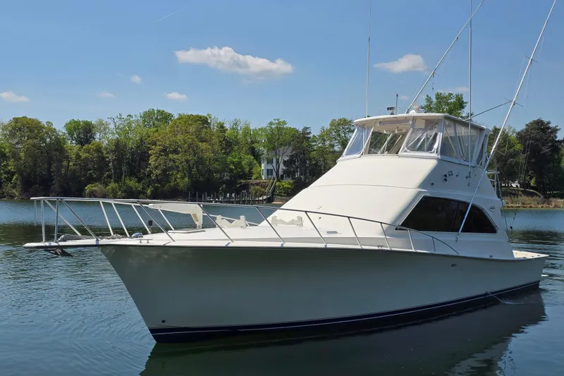 Slide: The Image of 1993 Ocean Yachts 53 Super Sport boat on calm water, surrounded by lush greenery. - 2