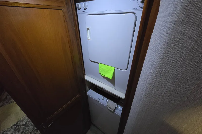 Slide: The Image of Laundry area inside 1993 Ocean Yachts 53 Super Sport, featuring a stacked washer and dryer. - 28