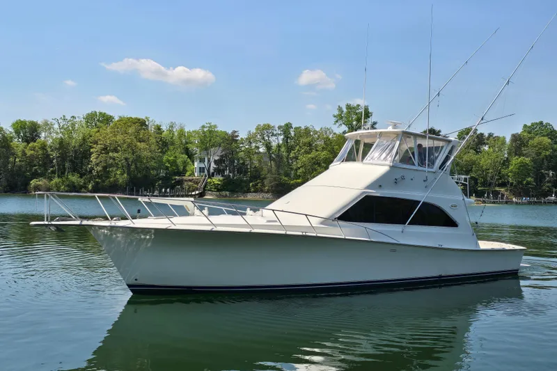Slide: The Image of 1993 Ocean Yachts 53 Super Sport boat on calm water, surrounded by lush greenery. - 3