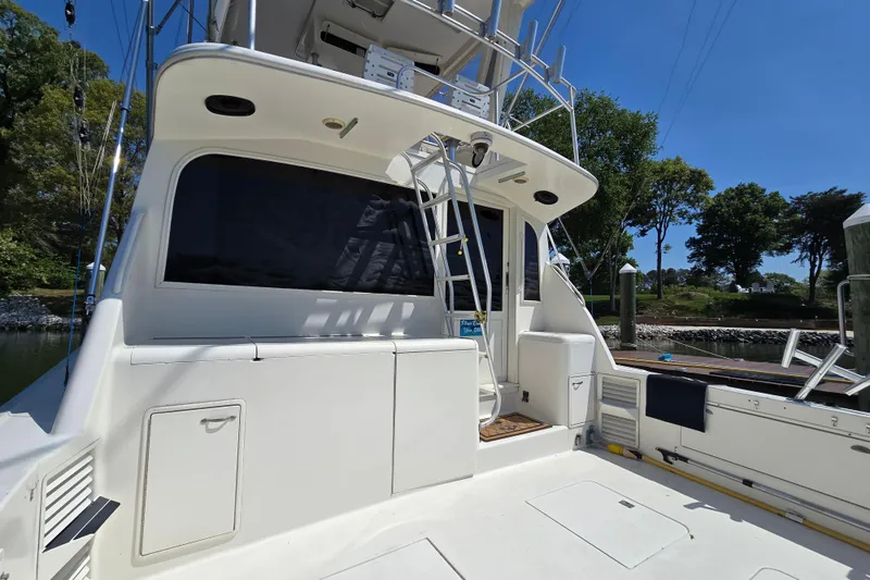 Slide: The Image of 1993 Ocean Yachts 53 Super Sport boat with ladder and spacious deck, docked by lush greenery. - 39