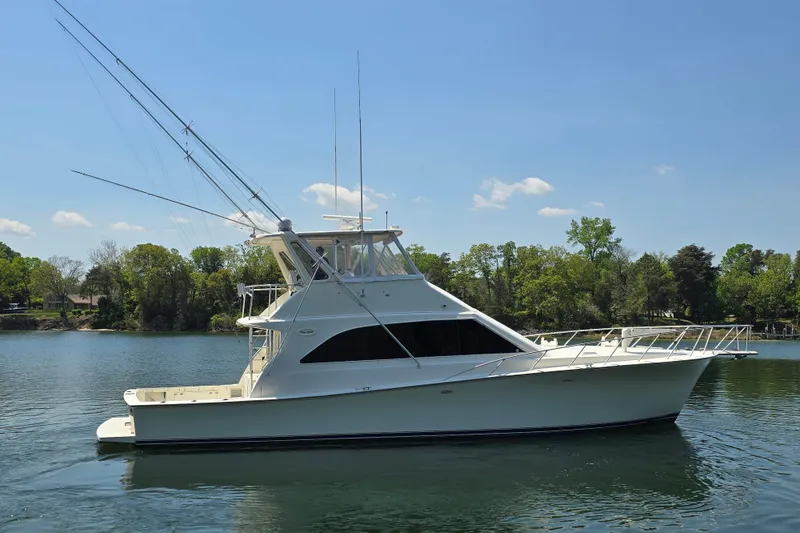 Slide: The Image of 1993 Ocean Yachts 53 Super Sport on calm water, surrounded by trees. - 4