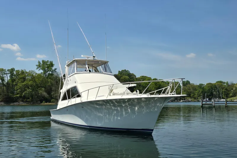 Slide: The Image of 1993 Ocean Yachts 53 Super Sport cruising on a serene lake under a clear blue sky. - 6