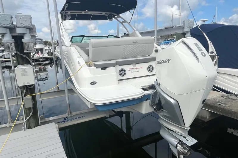 Slide: The Image of 2021 Sea Ray SDX 250 Outboard boat docked with Mercury engine, marina background. - 11