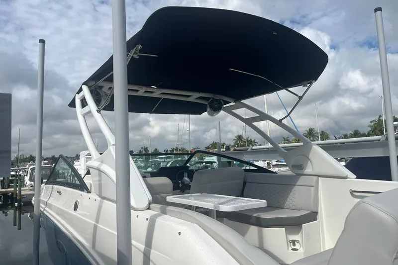 Slide: The Image of 2021 Sea Ray SDX 250 Outboard boat with canopy, docked under cloudy sky. - 14