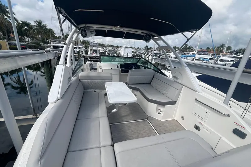 Slide: The Image of 2021 Sea Ray SDX 250 Outboard boat interior with seating and table, docked at marina. - 17