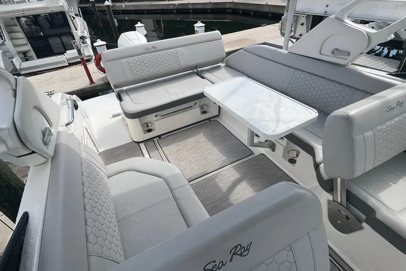 Slide: The Image of 2021 Sea Ray SDX 250 Outboard boat interior with gray seating and table at dock. - 19