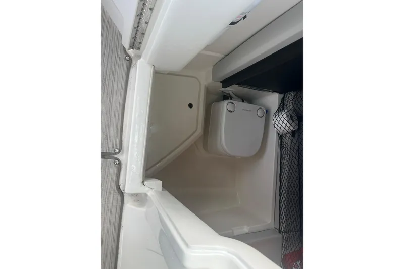 Slide: The Image of 2021 Sea Ray SDX 250 Outboard boat interior storage compartment with portable toilet. - 27