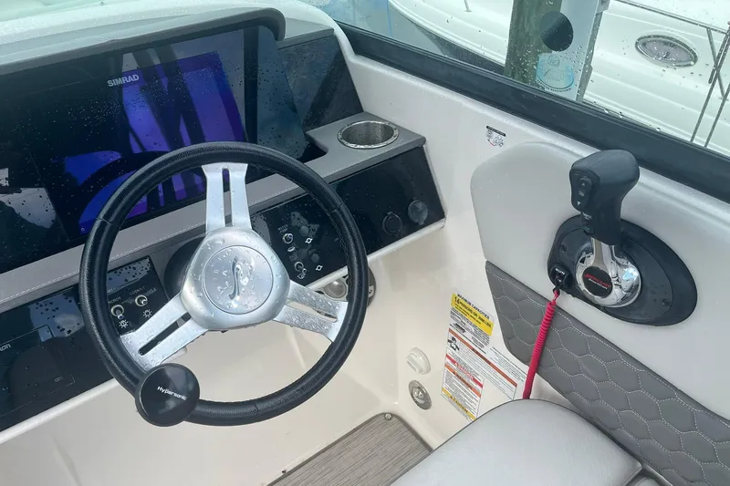 Slide: The Image of 2021 Sea Ray SDX 250 Outboard helm with steering wheel and control panel. - 28