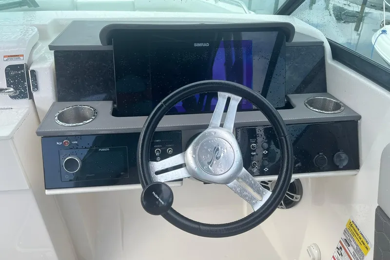 Slide: The Image of 2021 Sea Ray SDX 250 Outboard helm with steering wheel and control panel. - 29