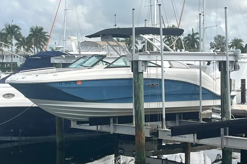 Slide: The Image of 2021 Sea Ray SDX 250 Outboard boat docked at marina with palm trees. - 4