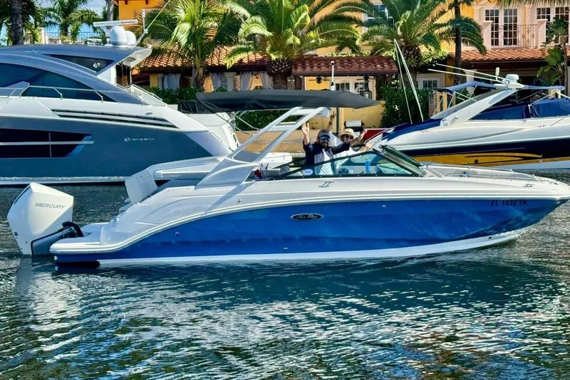Slide: The Image of 2021 Sea Ray SDX 250 Outboard boat cruising on a sunny day near palm trees. - 7