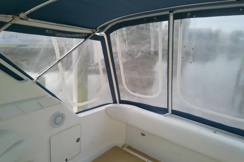 Slide: The Image of 1998 Sea Ray Sundancer 330 interior with blue canopy and clear windows. - 10