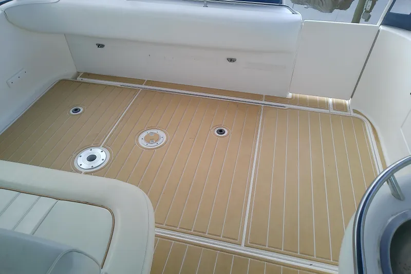 Slide: The Image of 1998 Sea Ray Sundancer 330 boat deck with tan flooring and white seating. - 12