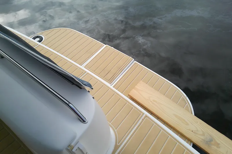 Slide: The Image of 1998 Sea Ray Sundancer 330 swim platform with teak decking, reflecting on calm water. - 14