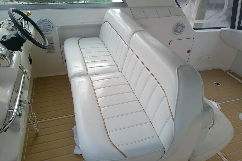 Slide: The Image of 1998 Sea Ray Sundancer 330 interior with white leather seating and wooden flooring. - 16