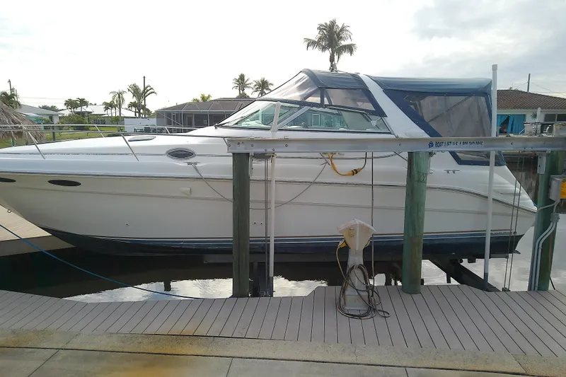 Slide: The Image of 1998 Sea Ray Sundancer 330 yacht docked, featuring sleek design and spacious cabin. - 2