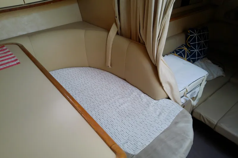 Slide: The Image of 1998 Sea Ray Sundancer 330 cabin interior with beige seating and decorative pillows. - 24
