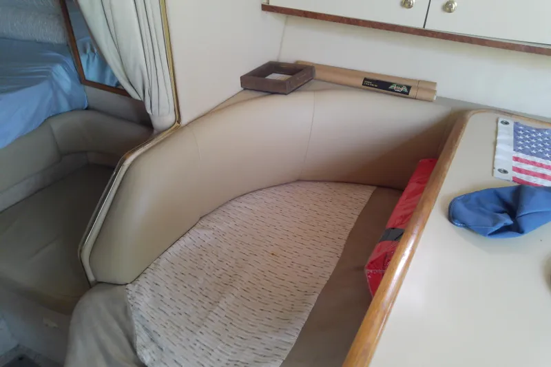Slide: The Image of 1998 Sea Ray Sundancer 330 cabin interior with seating, table, and American flag decor. - 25