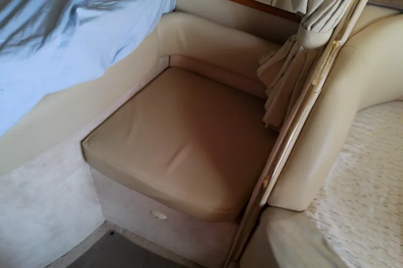 Slide: The Image of 1998 Sea Ray Sundancer 330 interior seating with beige upholstery and curtain detail. - 30