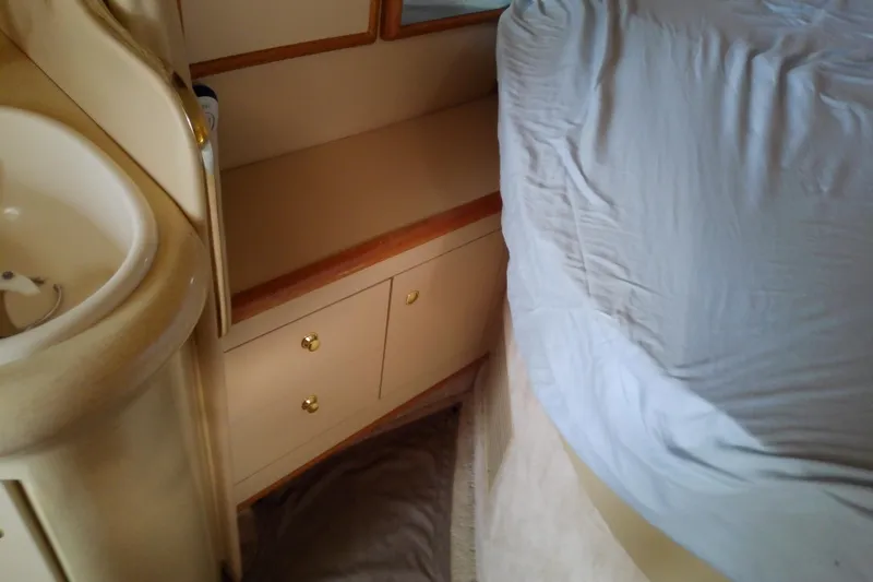 Slide: The Image of Interior cabin of 1998 Sea Ray Sundancer 330 with bed, sink, and storage cabinets. - 31