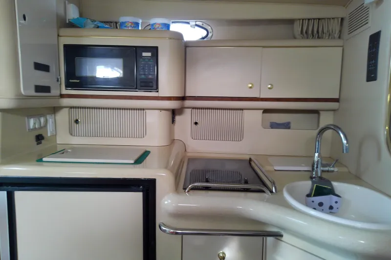 Slide: The Image of 1998 Sea Ray Sundancer 330 yacht kitchen with microwave, stove, and sink. - 32
