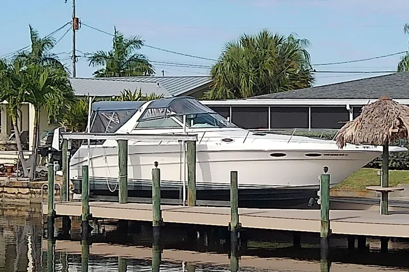 Slide: The Image of 1998 Sea Ray Sundancer 330 docked by a waterfront home with palm trees. - 46