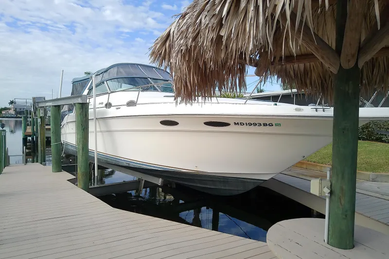 Slide: The Image of 1998 Sea Ray Sundancer 330 docked under a thatched roof, ready for adventure. - 5